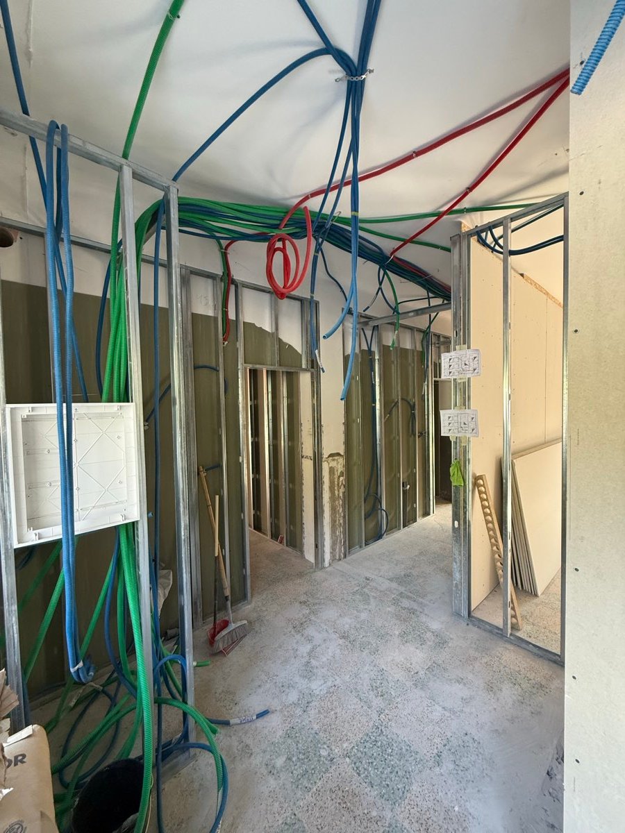 Obra em curso com tubagens de água e cabos elétricos nas paredes